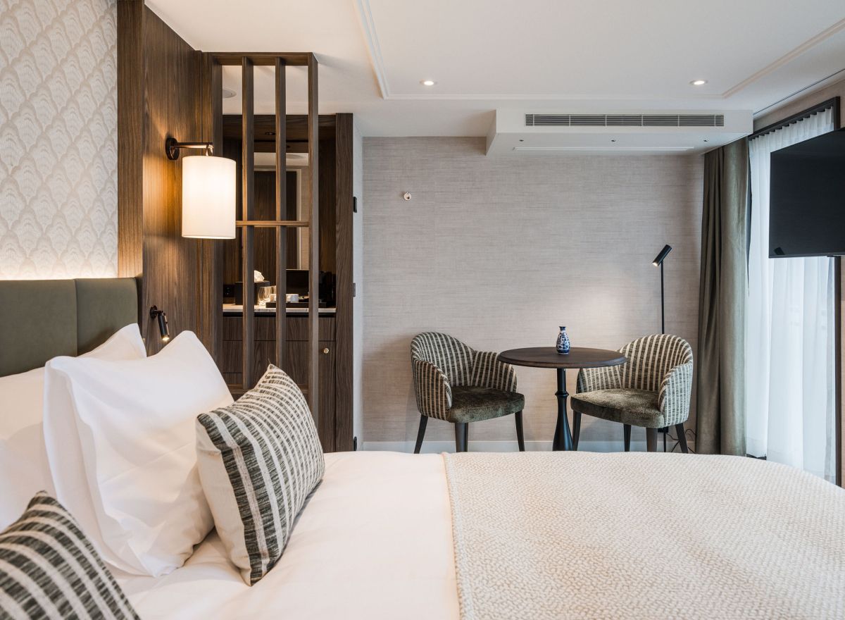 Spacious suite-style river cruise cabin with a seating area, large window frontage, modern furnishings, and elegant décor.